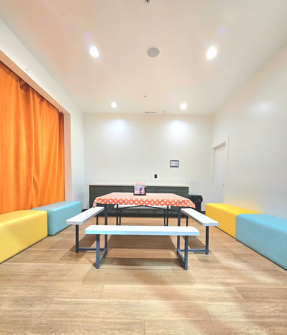Funrise party room with bench seating, table space, and bright walls