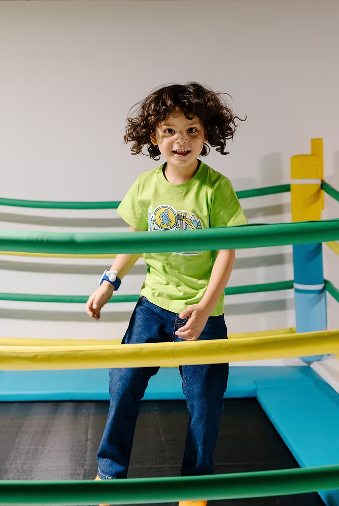 Child smiling on an indoor bridge feature at Funrise in Cedar Hills