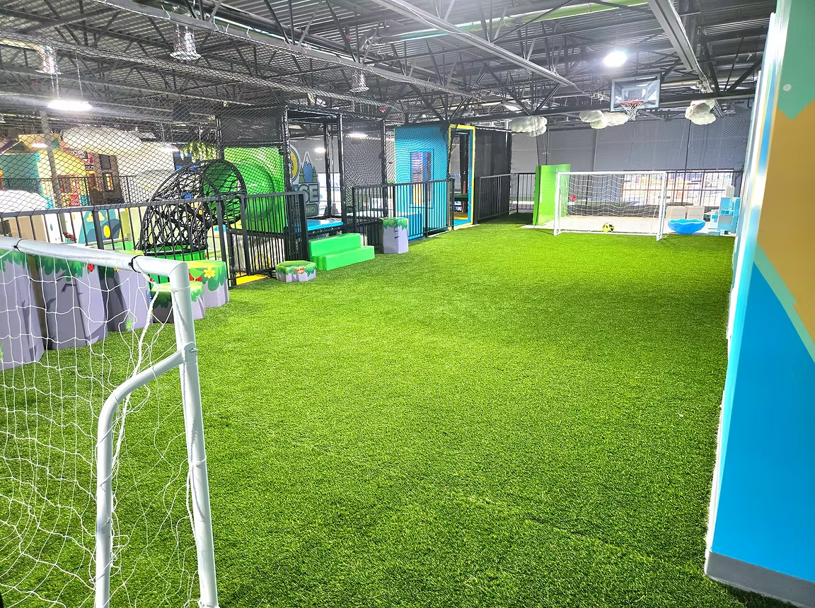 Indoor turf sports area with goals and active play space at Funrise in Cedar Hills