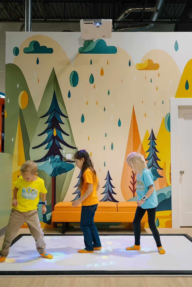 Children climbing on a mural wall inside Funrise Indoor Playground in Cedar Hills