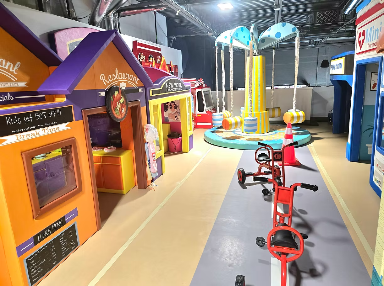 Bright Funrise indoor playground village with playhouses, ride-on toys, and climbing structures in Cedar Hills, Utah