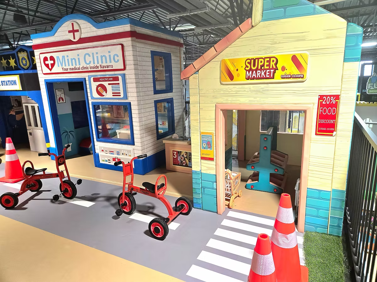 Funrise play village with pretend storefronts and ride-on toys for young children
